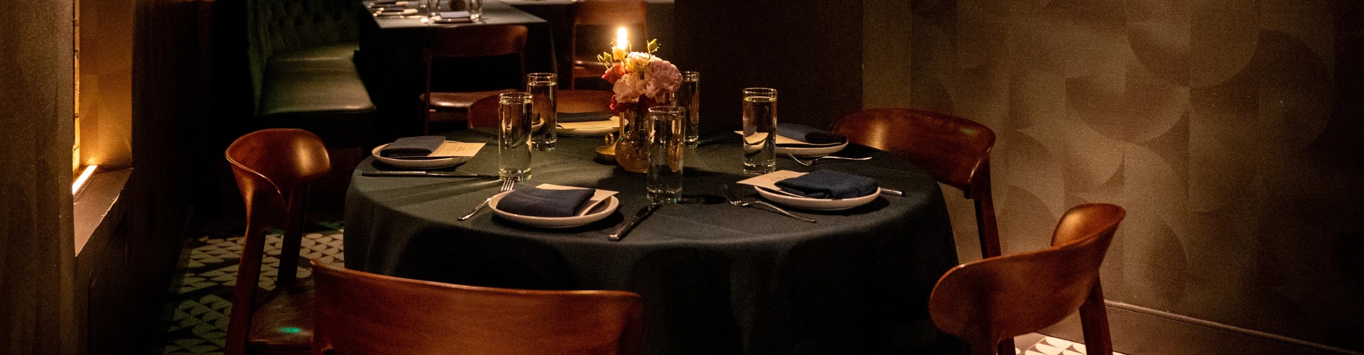 a table with a candle and glasses