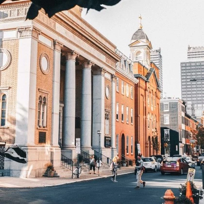 a street with a building and people walking on it