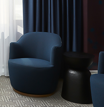 A seating area with blue chairs and a geometric-patterned rug.