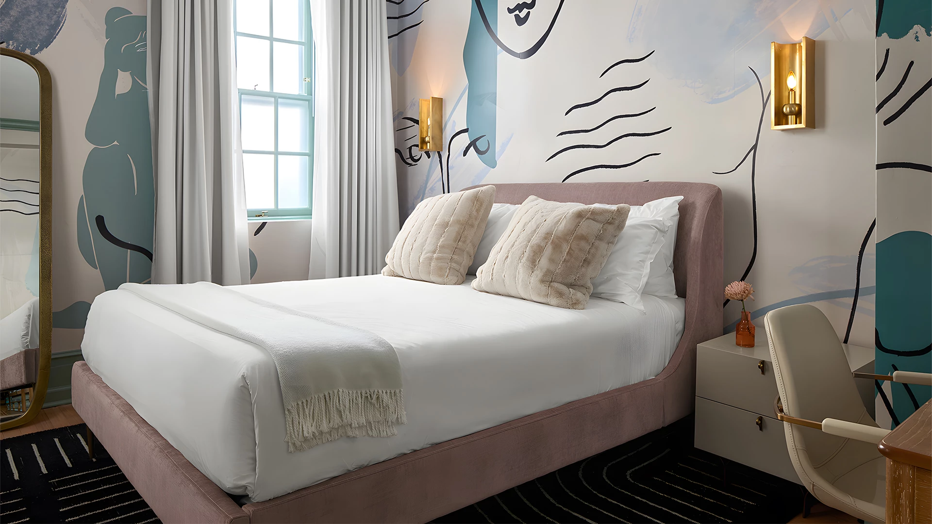 A wide view of a hotel room with a large bed, chair, and nightstand.