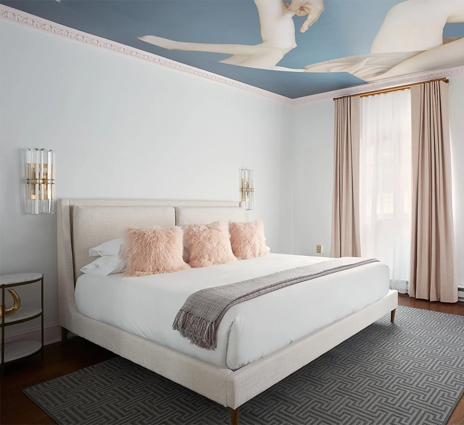 A luxurious hotel room with a large bed, comfortable bedding, and elegant decor.