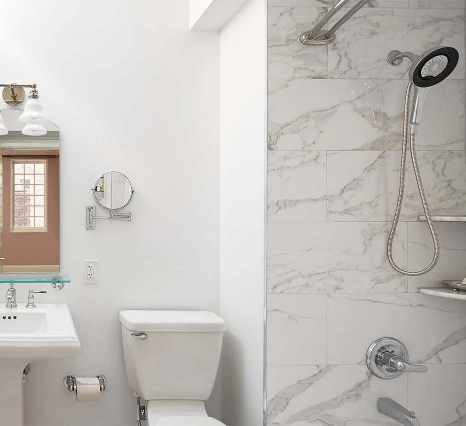 A clean and modern bathroom with a shower, toilet, and sink.