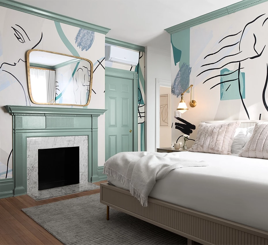 A bedroom with a bed, fireplace, and abstract wall art