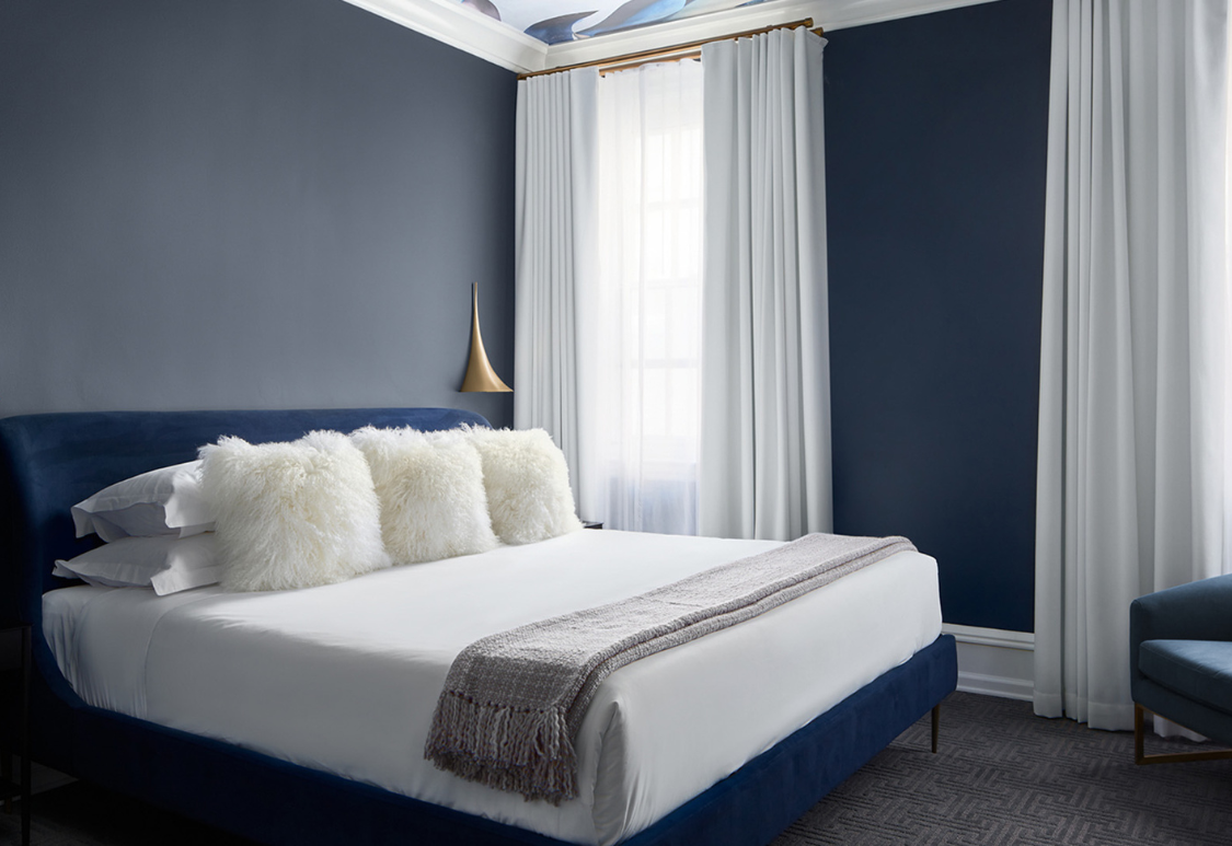 Post image for a bed with white pillows and a blue wall