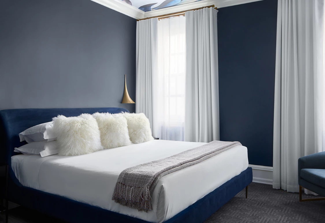 Post image for a bed with white pillows and a blue wall
