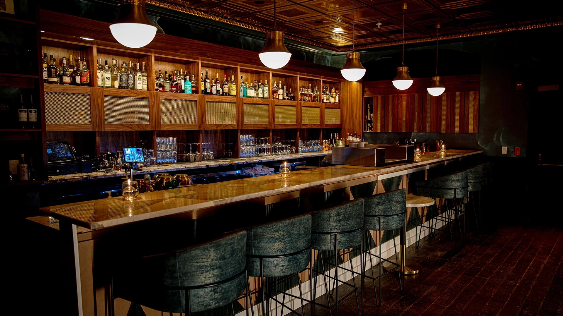 a dimly lit bar with a long counter and several stools