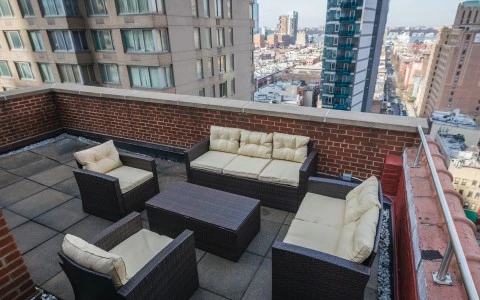 A rooftop patio with a seating area overlooking the city.