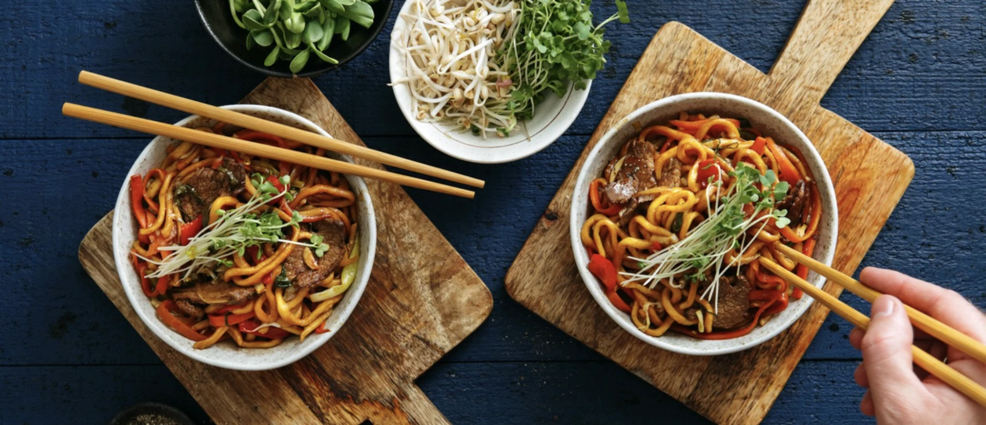 a table with two bowls of noodles and vegetables