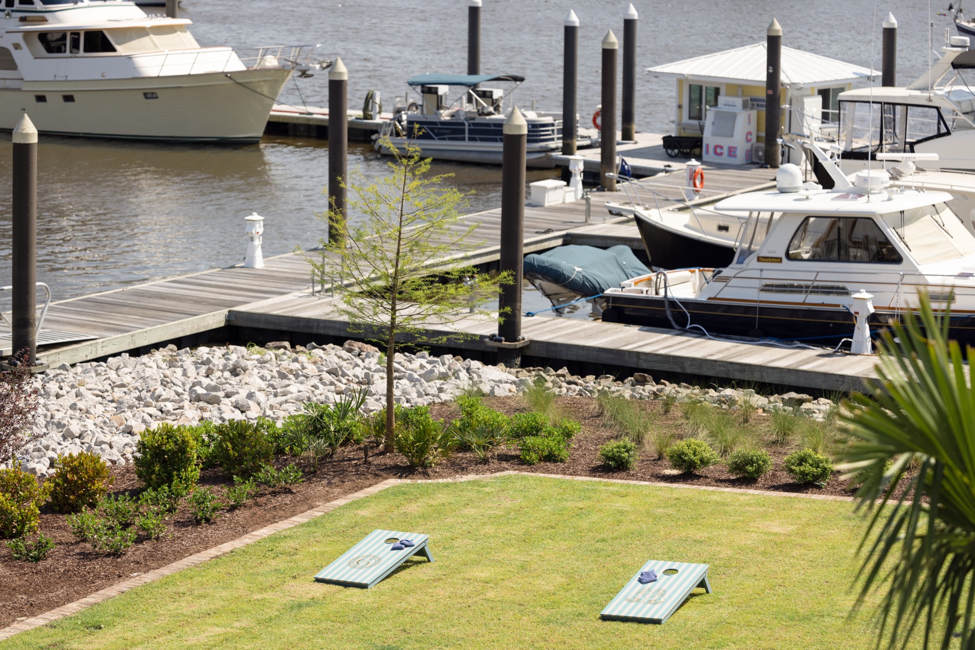 a lawn with a lawn chair and a boat in the water