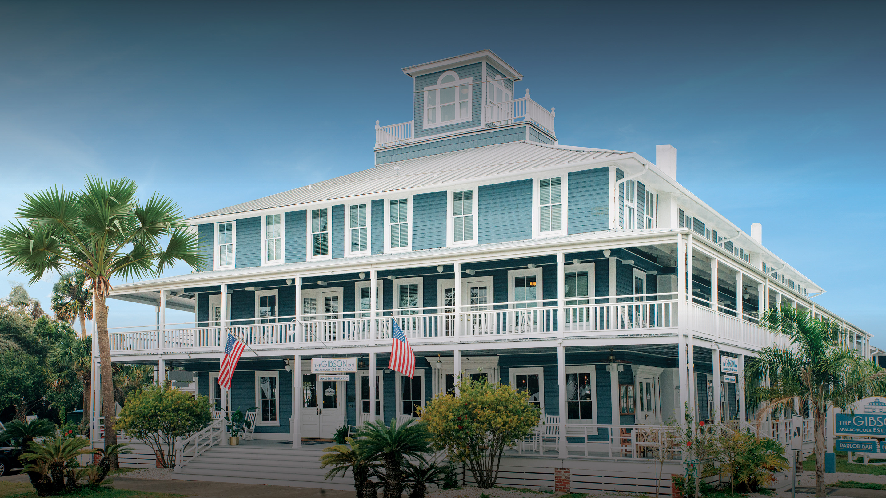 a large white building with palm trees