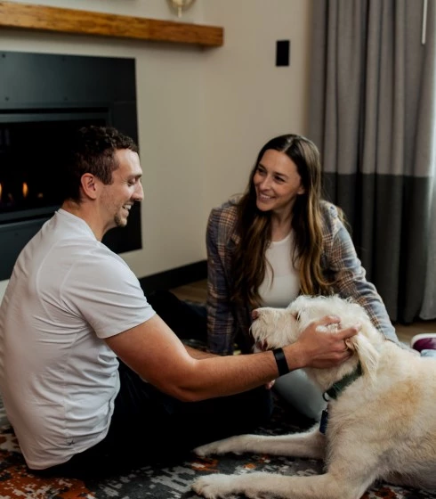 a man and woman petting a dog