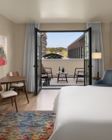 interior view of the deluxe king terrace room at The Gordon Hotel featuring king bed and open doors leading to terrace