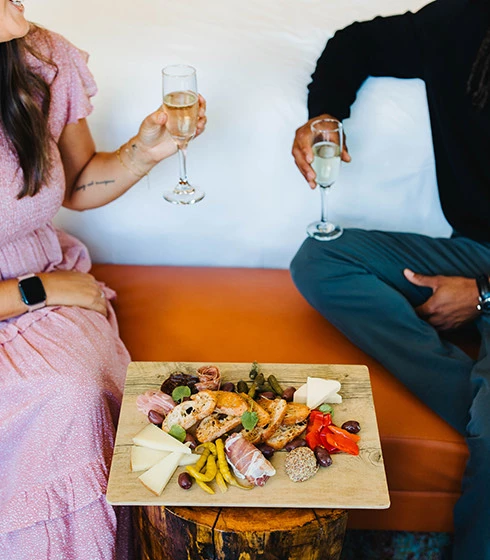 a couple of people sitting at a table with food and drinks