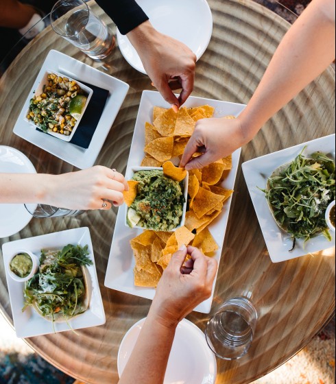 Friends enjoying tacos and chips and guac at Carlita's rooftop grill