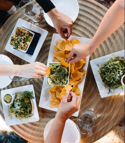 Friends enjoying tacos and chips and guac at Carlita's rooftop grill