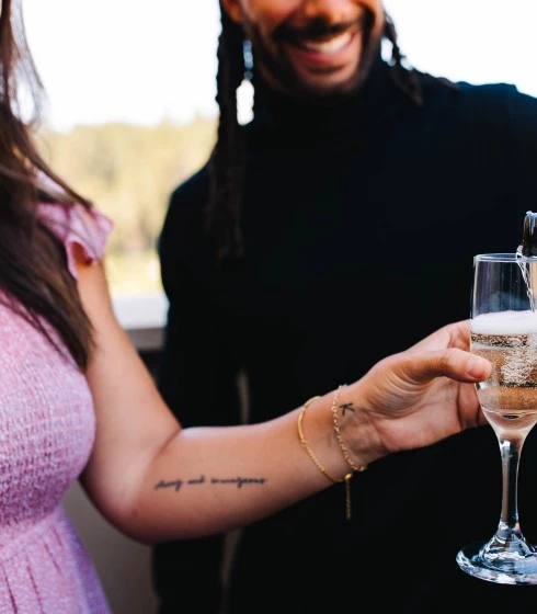 a man pouring a glass of champagne into a woman's hand