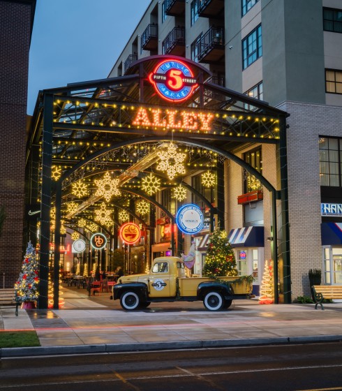a yellow truck parked in front of a building with christmas lights