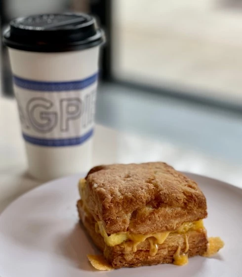 egg biscuit in a plate and a coffee in the back