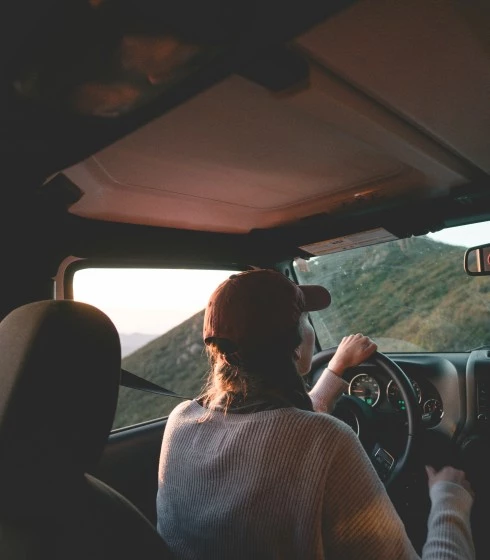 A woman on a road trip enjoying a beautiful view