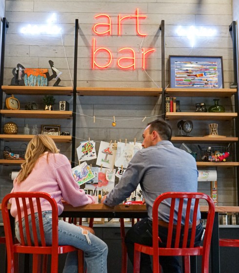 A couple sitting at the Gordon Hotels Art Bar creating art