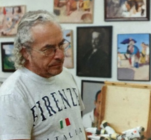 a man looking down at a painting