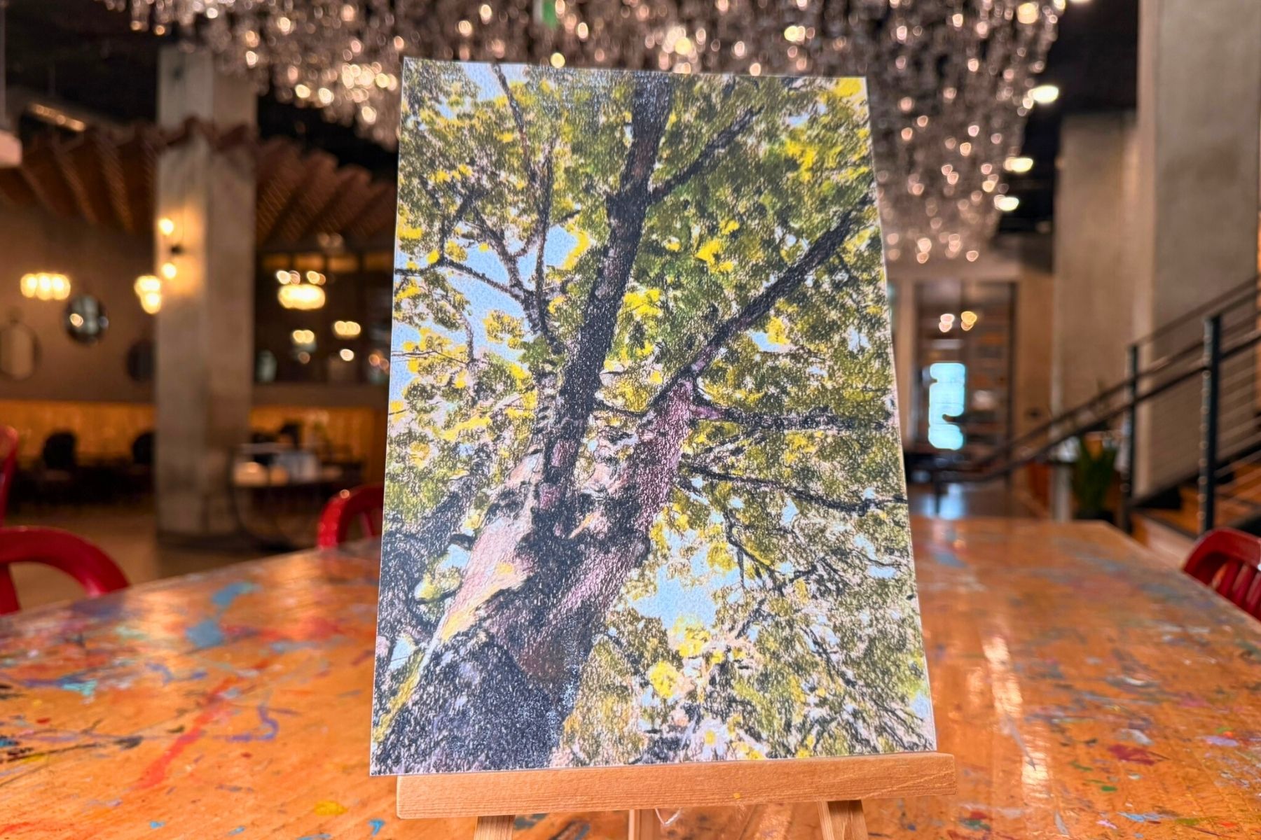 a painting of a tree on a wooden easel