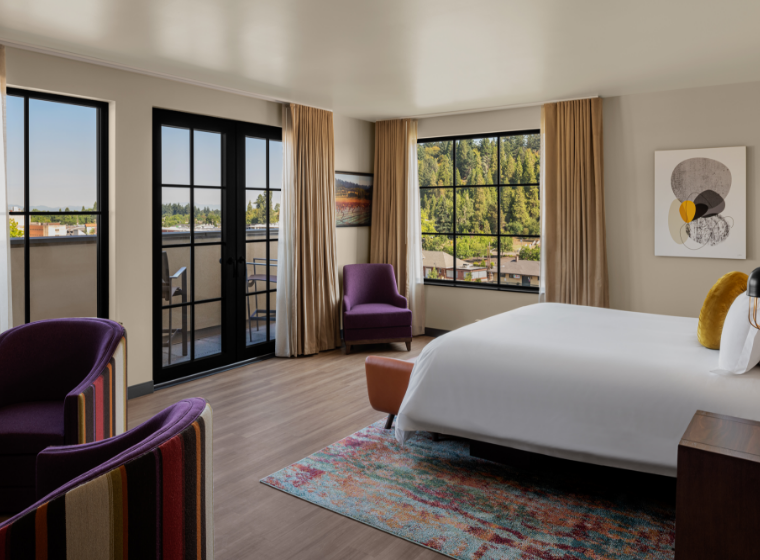 a room with a bed and chairs