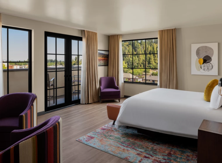 a room with a bed and chairs