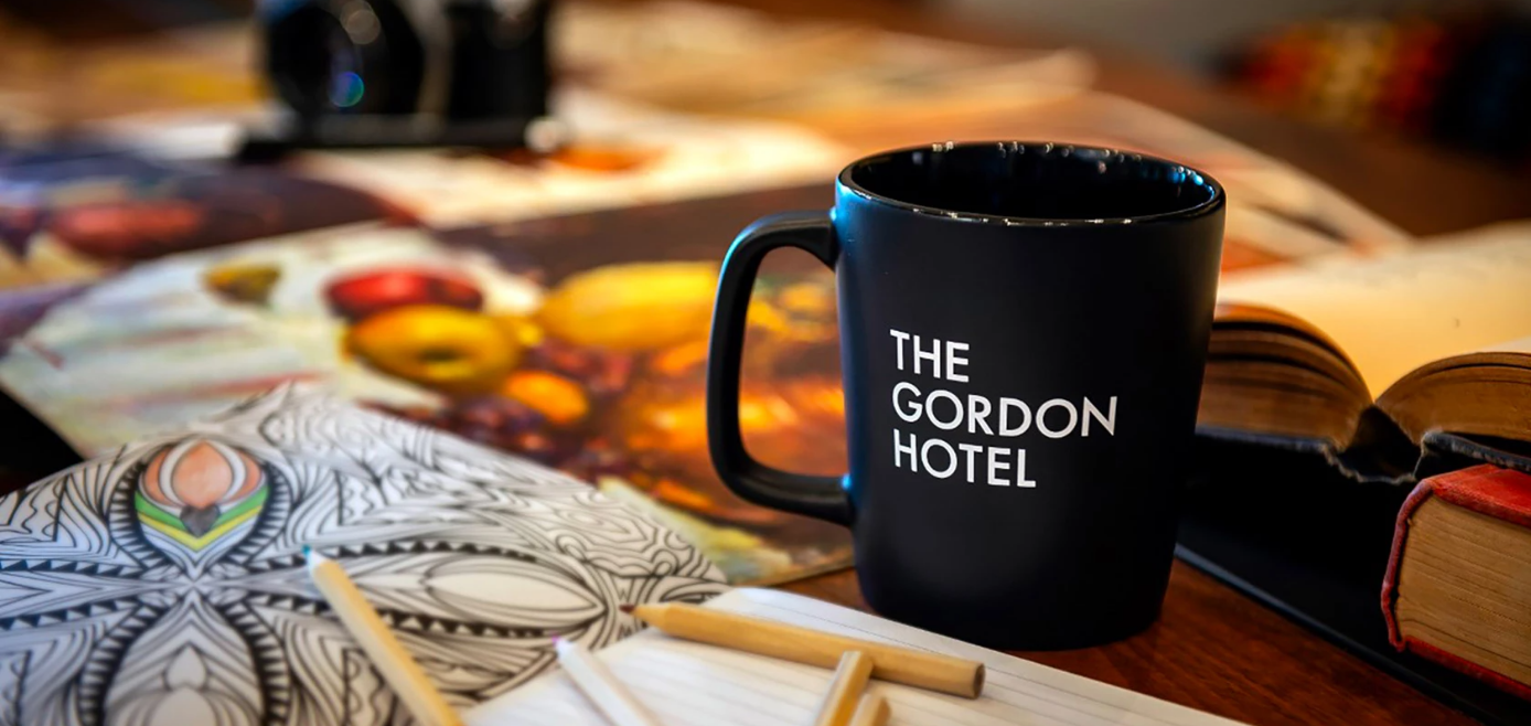 a black mug with white text on it next to pencils