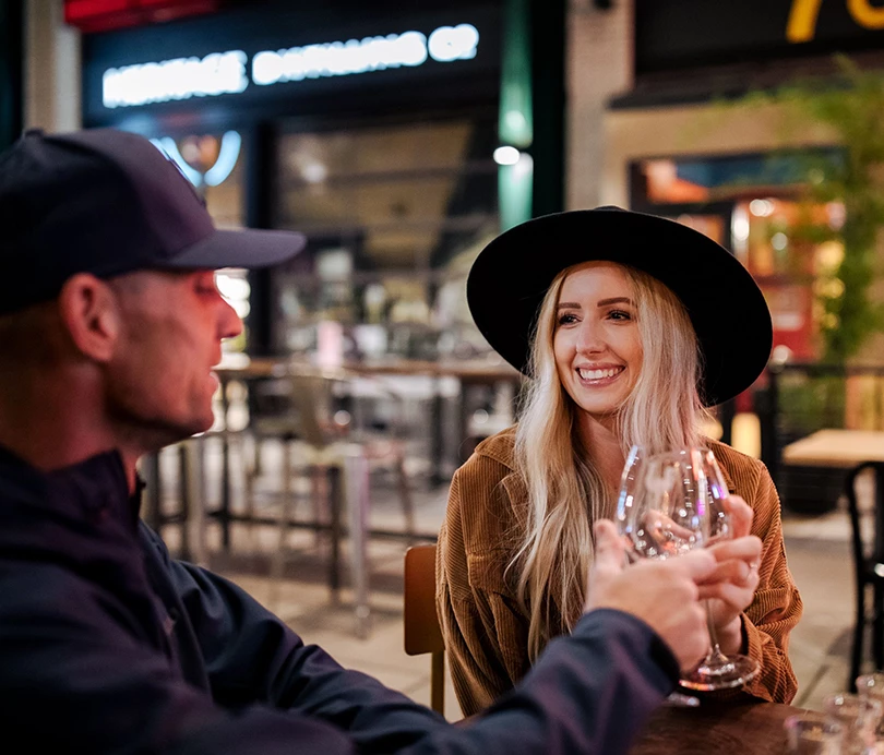 a man and woman sitting at a table with wine glasses
