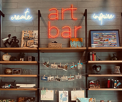 a shelf with art and pictures on it