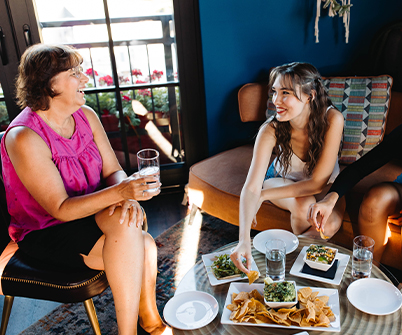 a group of women sitting on a couch and eating