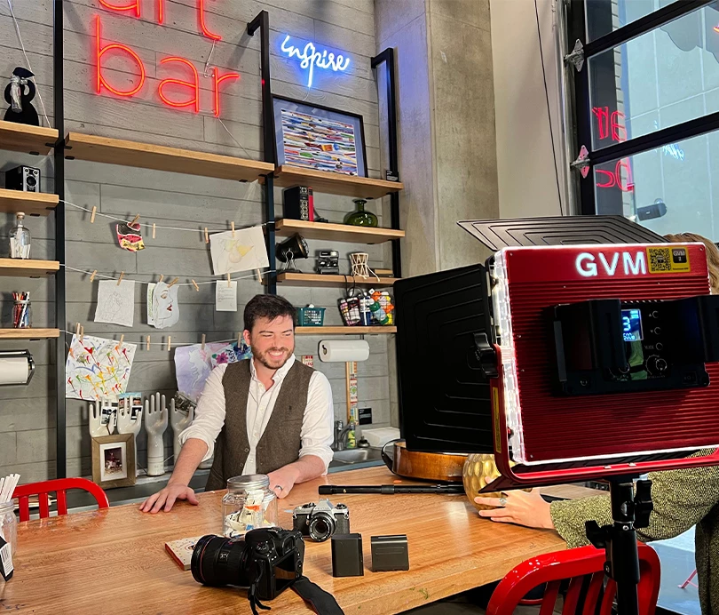 a man sitting at a table in front of a camera