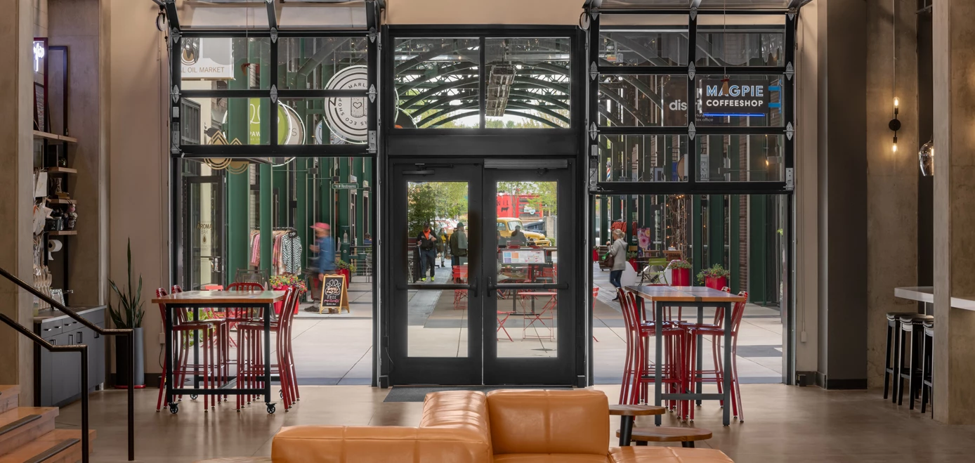 a glass doors with tables and chairs in a building