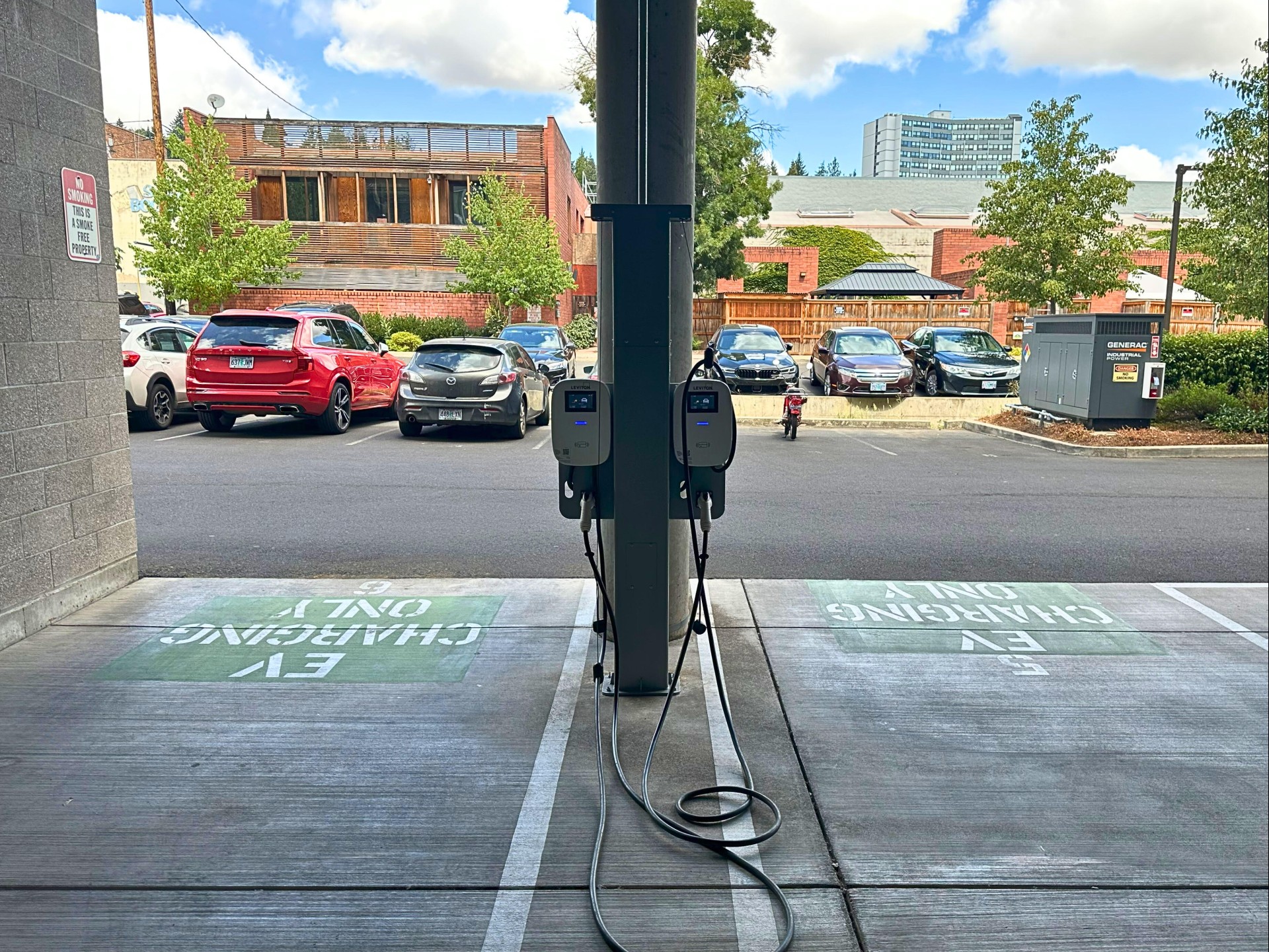 a charging station with cars parked in the background