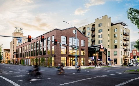 a street with people riding bikes across the street and a building in the back