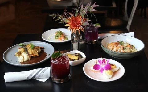 a table with plates of food and flowers