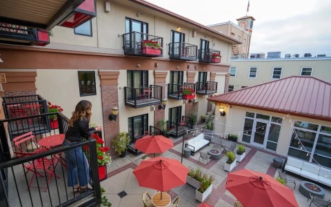 a woman standing on a balcony with red umbrellas