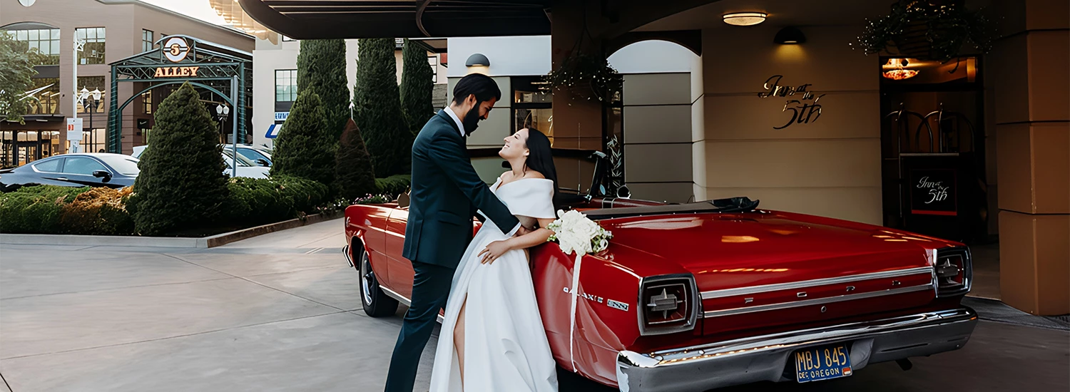 a man and woman in a suit and suit standing next to a red car