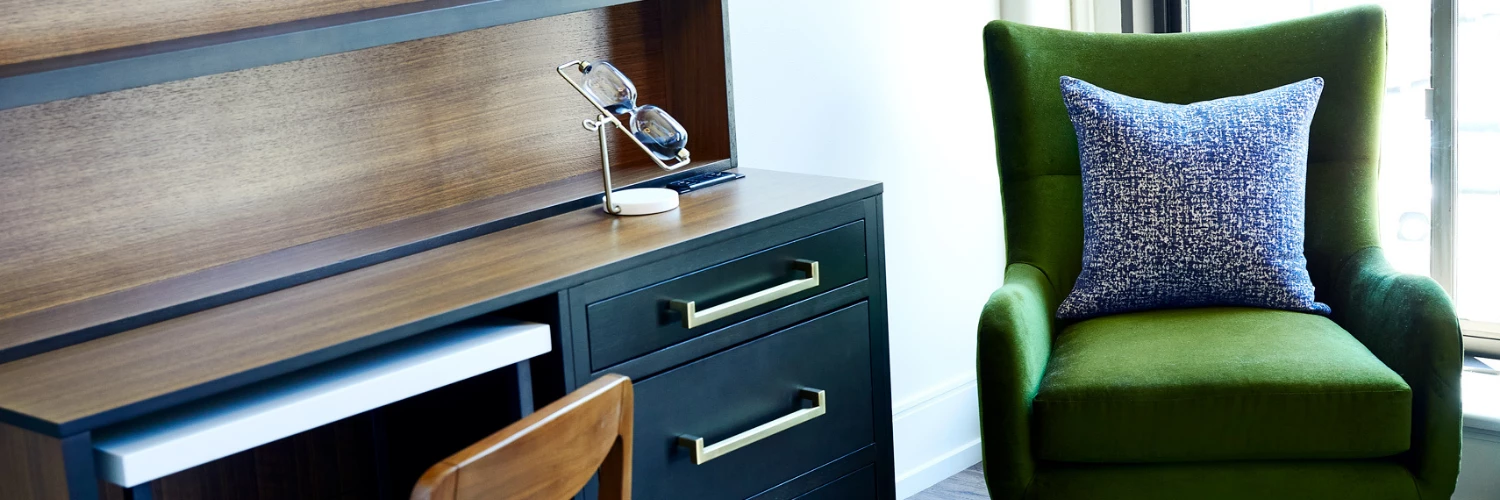 view of desk and green velvet chair in a suite