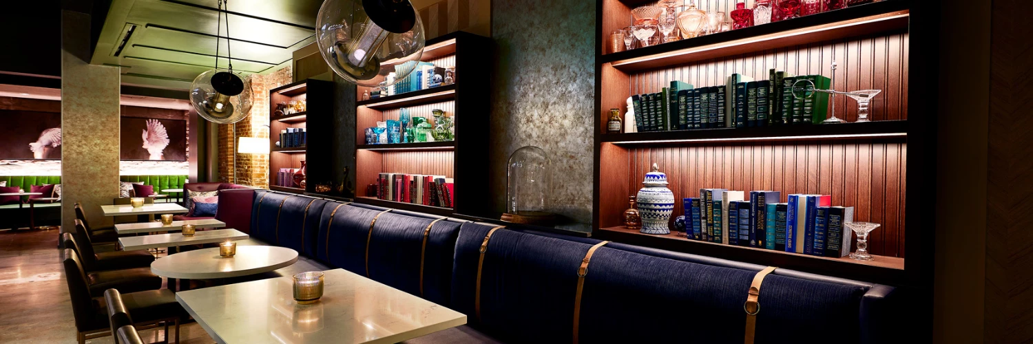 view of restaurant seating area with dim lighting and vintage styled furniture