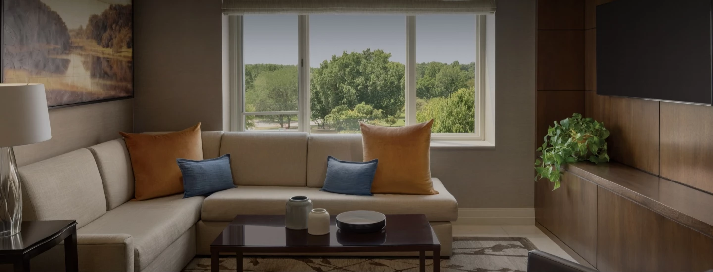 a couch with pillows and a coffee table in front of a window