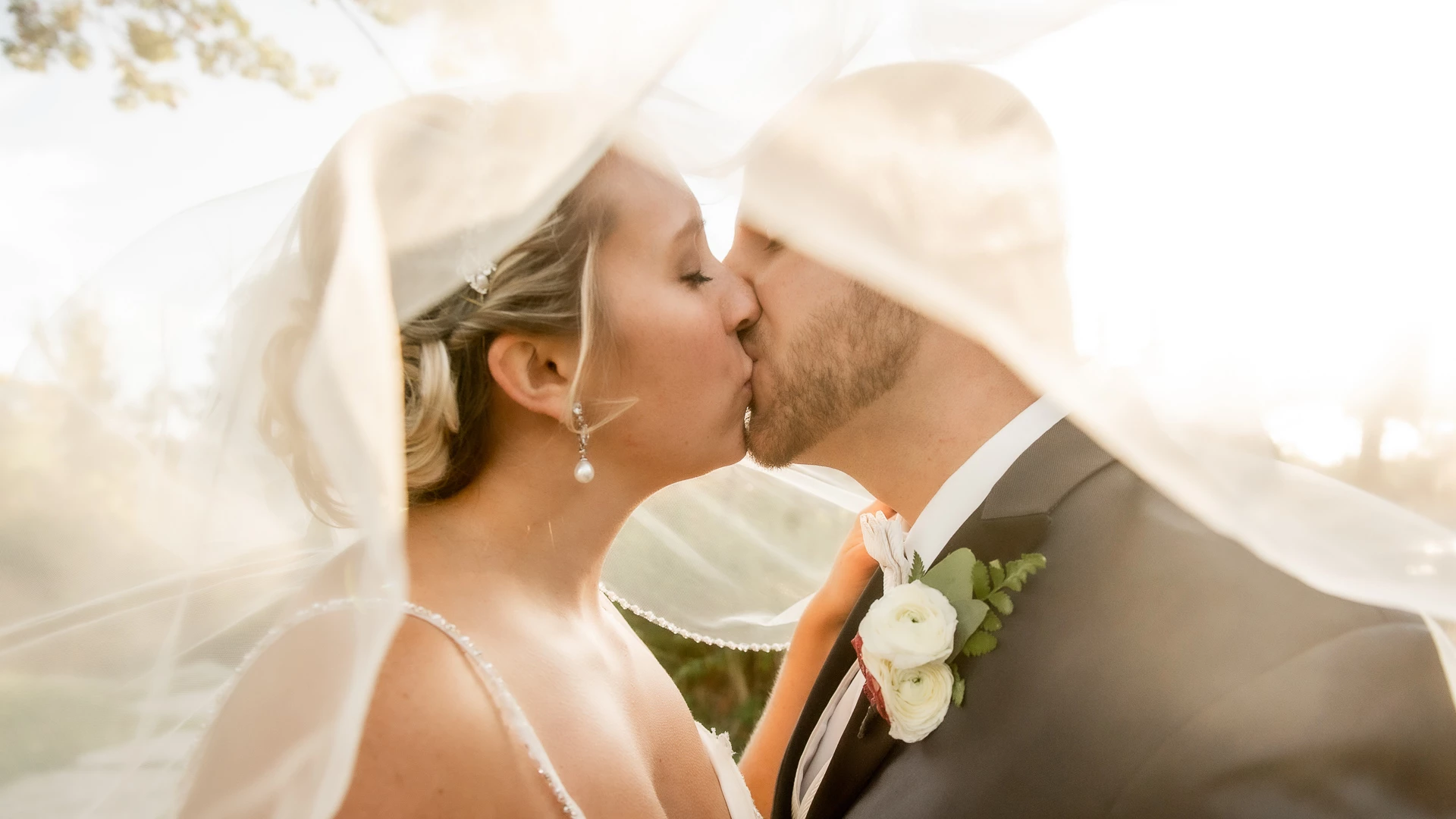 a man and woman kissing under a veil