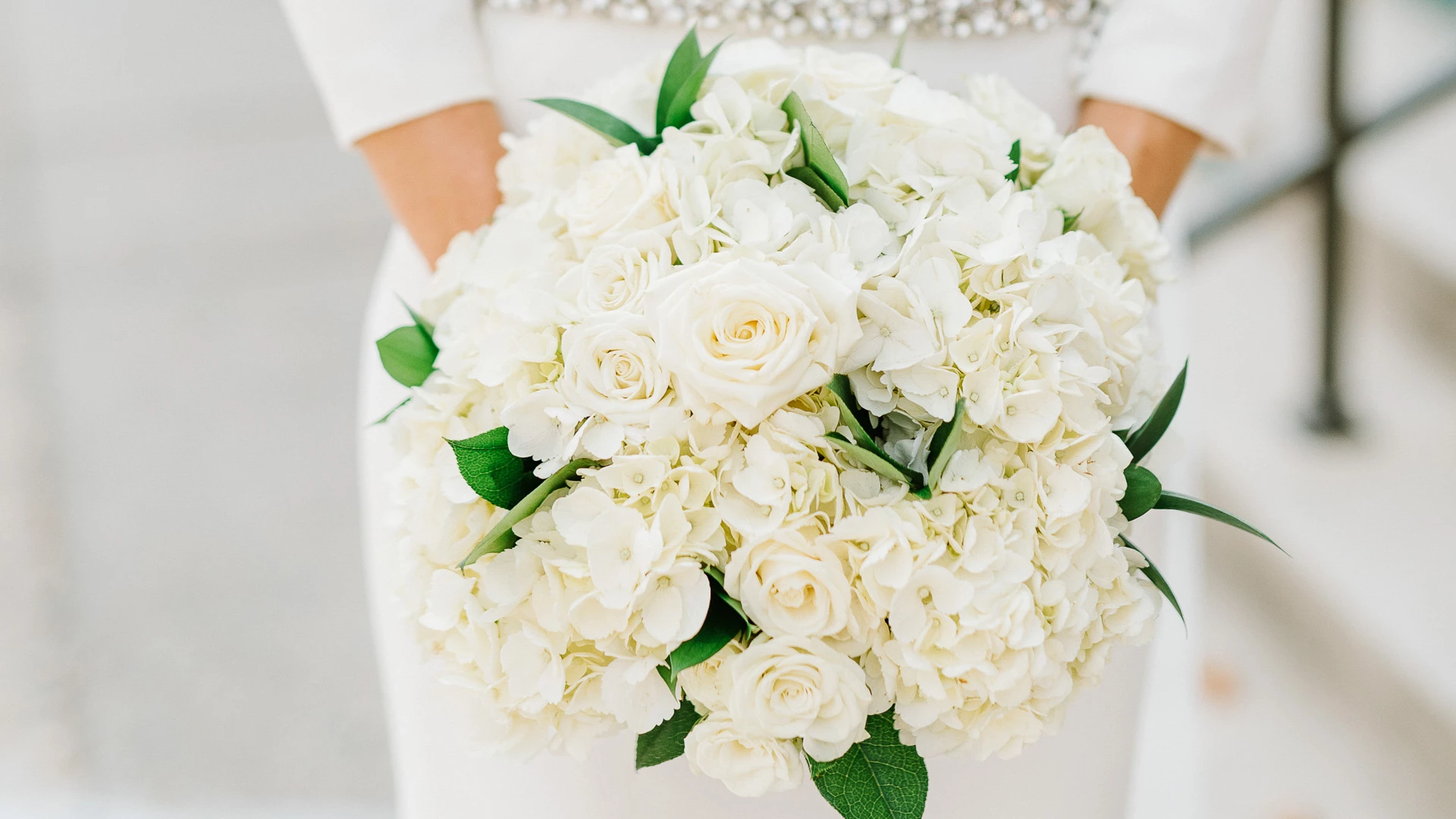 a person holding a bouquet of white flowers