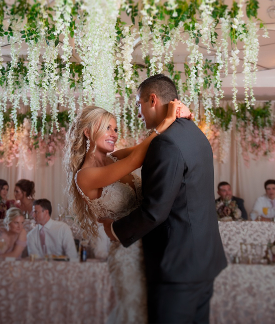 a man and woman dancing in a room with flowers