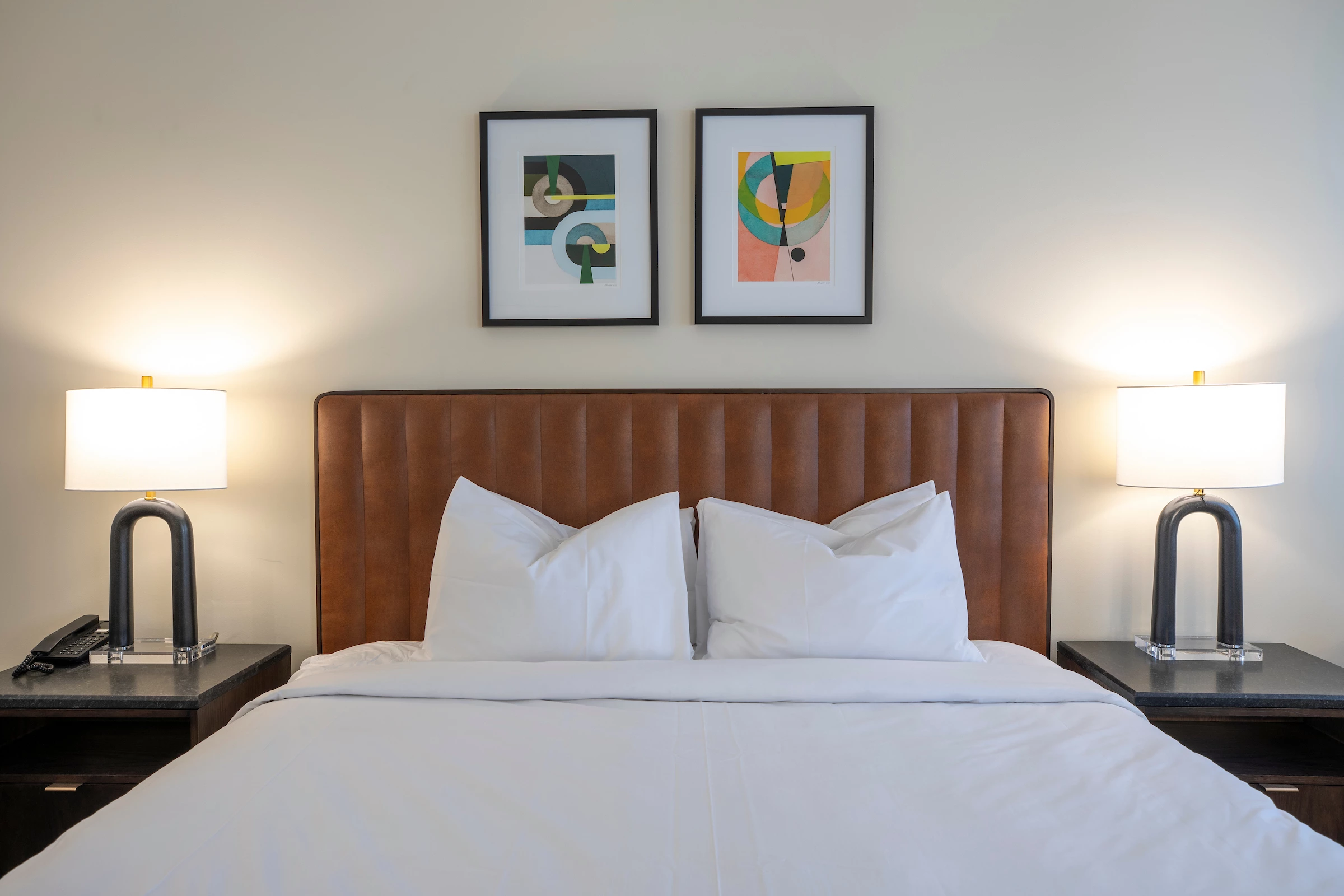 a bed with white sheets and pillows