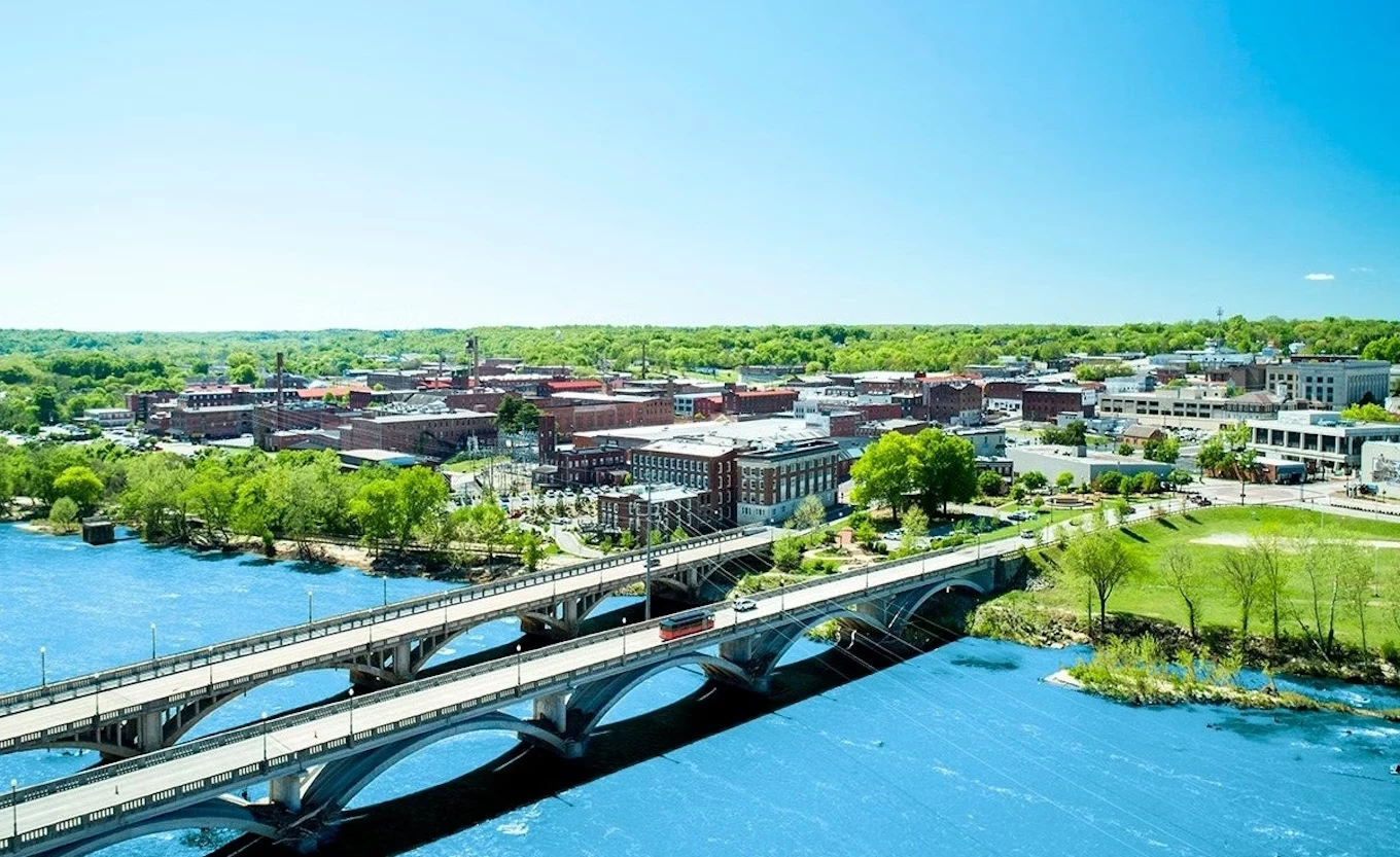 a bridge over a river with buildings and trees