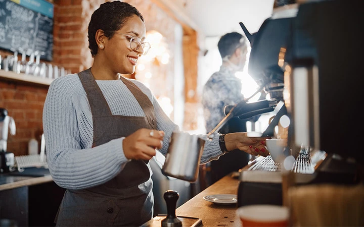 a person pouring a liquid into a cup