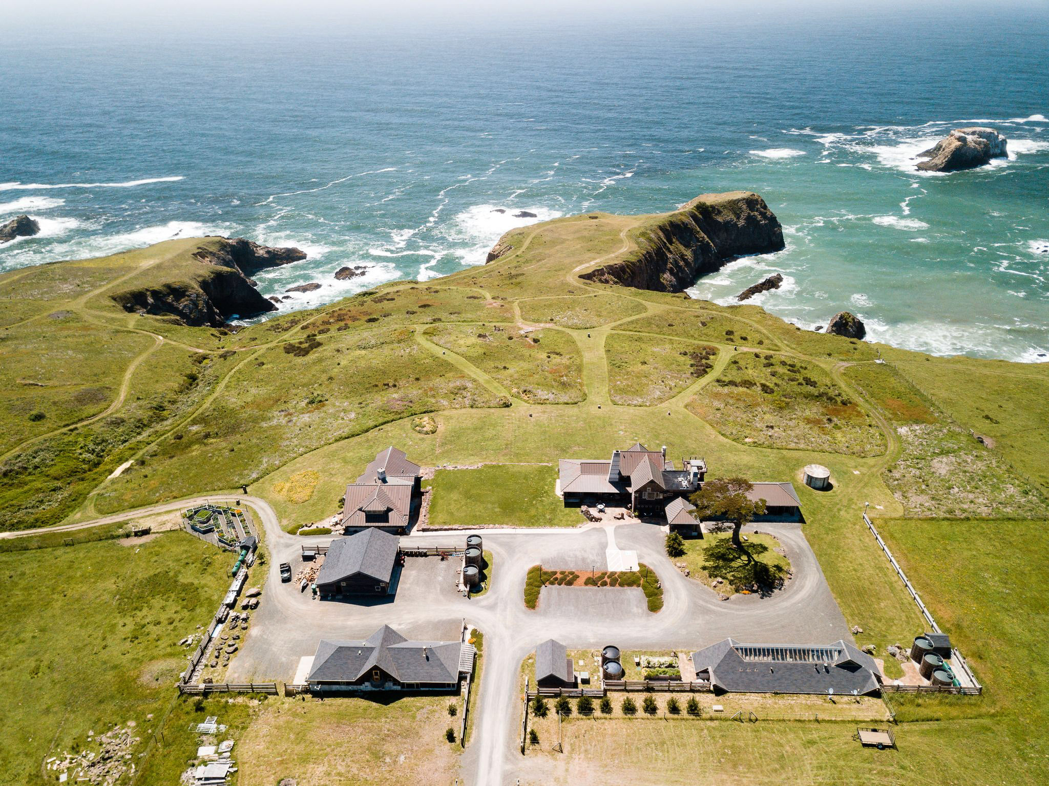 a houses on a grassy hill by the ocean