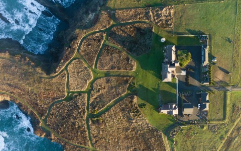 a aerial view of a house and a large grassy area